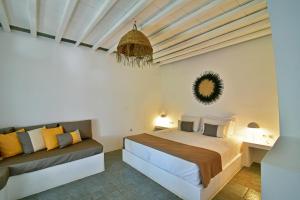 a bedroom with a bed and a couch at Myrto Bungalows in Artemonas