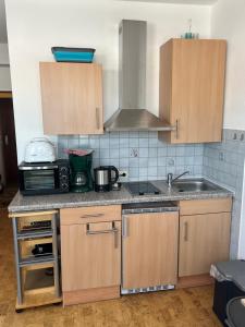 a kitchen with wooden cabinets and a sink at Vor den Toren zum Adventure Spielberg Am Rothaarsteig in Medebach