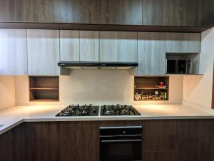 a kitchen with a stove and wooden cabinets at La Regina in Quito