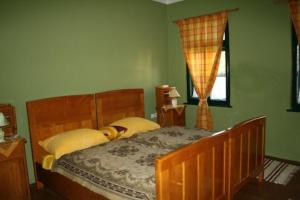 sypialnia z drewnianym łóżkiem i oknem w obiekcie Seoski Turiziam Larva w mieście Trenkovo