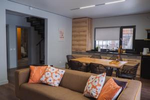 a living room with a couch and a table at Tabi Village Mountain Nest in Uchastkovoyye Khozyaystvo SKhI