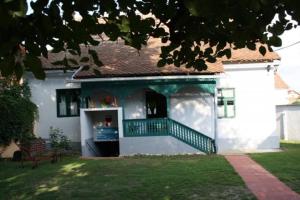 a white house with a green and white balcony at Seoski Turiziam Larva in Trenkovo