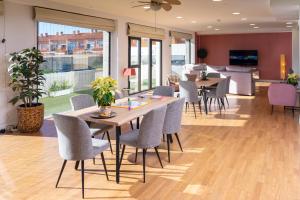 una sala da pranzo con tavoli, sedie e finestre di Alojamientos VEN -Vista Extremadura Norte a Plasencia