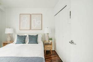 a white bedroom with a bed with blue pillows at 809-5A Gorgeous New 1BR Heart of Midtown in New York +19 photos