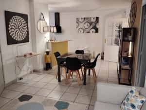 a living room with a dining room table and chairs at Charmant appartement 2 chambres - Proche Tours in Joue-les-Tours +5 photos