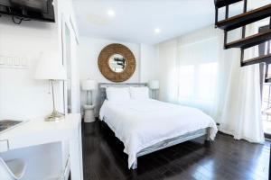 a white bedroom with a bed and a mirror at 809-6B New 2BR Duplex With Private Patio in New York