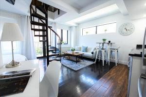 a kitchen and living room with white walls and wooden floors at 809-6B New 2BR Duplex With Private Patio in New York