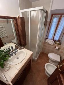 a bathroom with a sink and a shower and a toilet at La Casa nel Borgo - Licenza in Licenza
