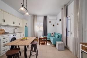 a kitchen with a table and a blue couch at Aroma Kastellia - Althea Homes in Amoopi