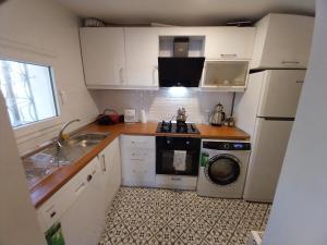 a small kitchen with a sink and a washing machine at Tiny House in Konak