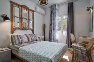 a bedroom with a bed and a chair and a window at Aroma Kastellia - Althea Homes in Amoopi