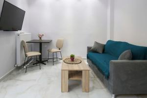 a living room with a blue couch and a table at #D Ioanna Apartments in Thessaloniki