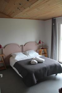 a bedroom with a large bed with a wooden ceiling at Le Saint-Germain - Maison en bois en pleine nature in Saint-Germain-Chassenay