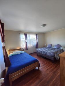 a bedroom with two beds with blue sheets in it at Hospedajes Roma in Valdivia +19 photos