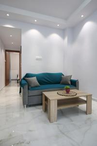 a living room with a blue couch and a coffee table at #C Ioannas Apartments in Thessaloniki