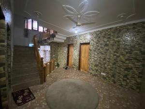 un corridoio con un ventilatore a soffitto e un muro di mattoni di VisitingVillah a Srinagar Altre 47 foto