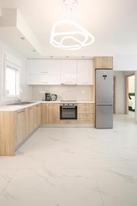a kitchen with wooden cabinets and a stainless steel refrigerator at #8 Ioanna Apartments 2bedrooms in Thessaloniki +14 photos