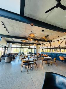 a dining room with tables and chairs and windows at 13A Elizabeth Place - Beautiful self catering 2 bedroom unit next to Kyalami Racetrack with free WiFi - swimming pool gym and restaurant - Perfect for a small family in Midrand Waterfall in Kyalami