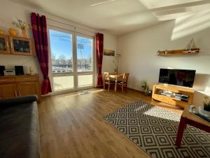 a living room with a couch and a television and a table at Am Altstadt - Yachthafen in Greifswald