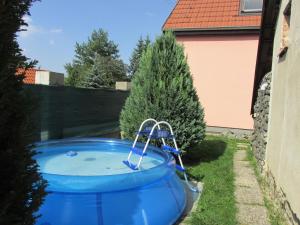 a large blue pool in a yard with trees at Chata Lucie in Roudnice nad Labem