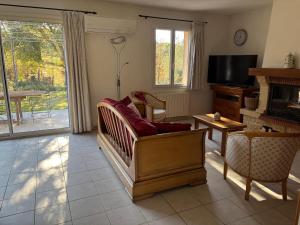 a living room with a couch and a television at Villa provençale dans le Golfe de Saint Tropez in Grimaud