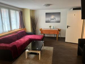 a living room with a red couch and a table at Hotel Bären Amriswil in Amriswil