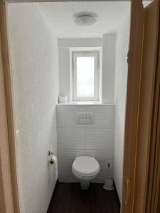 a small bathroom with a toilet and a window at Hotel Bären Amriswil in Amriswil