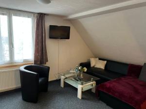 a living room with a couch and a tv at Hotel Bären Amriswil in Amriswil