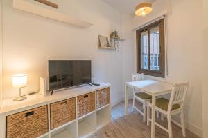 Habitación con escritorio, TV y mesa. en Welcomy Sant Andreu, en Barcelona
