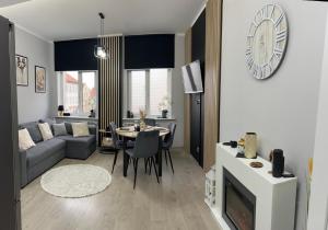 a living room with a couch and a table at Landsberg Studio Apartment in Górowo Iławeckie