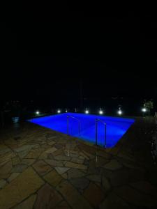 a blue pool is lit up at night at Casa de campo em Gaspar in Gaspar +24 photos