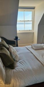 a bedroom with a bed with a large window at North Coast Property - Avoch Beach House - Luxury house with sea views in Avoch