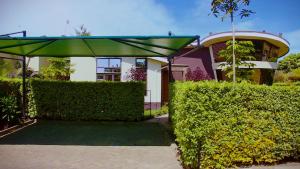 a house with a green hedge in front of a building at La Casa Savanna in Naivasha