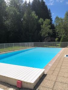 une grande piscine bleue avec une clôture blanche dans l'établissement Studio Résidence grand tetras, à Samoëns