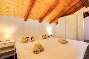 a bedroom with a large white bed with towels on it at Holiday home ZEN in Vinkovac +49 photos