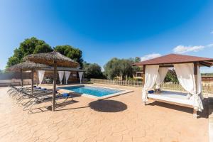 a swimming pool with two gazebos and a swimming poolvisor at Son Sea Villa in Campos