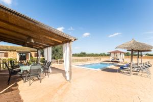 a patio with a table and chairs and a umbrella at Son Sea Villa in Campos