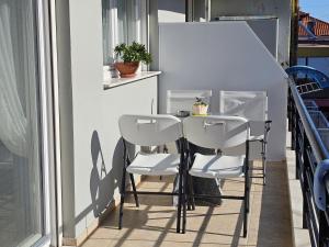 a table and two chairs on a balcony at Tania Apartments in Leptokaria