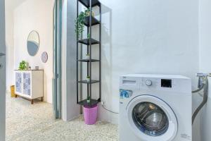 a laundry room with a washing machine and a shelf at Lilly the Traditional Maltese Townhouse in Sliema in Sliema