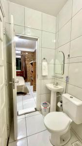 a white bathroom with a toilet and a sink at Chalés Santo Antônio em Flecheiras in Flecheiras