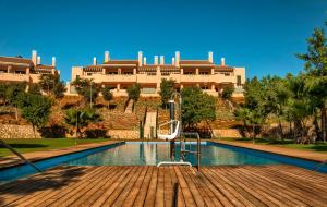a swimming pool in front of a large building at Casa Isabella- Precioso apartamento en El Oasis Hacienda del Alamo in Fuente Alamo