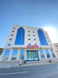a large building with blue windows on a street at Maidan Al Bait in Makkah