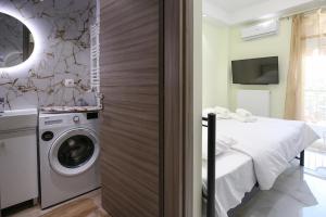 a bathroom with a washing machine and a bed at #7 Ioanna Apartments in Thessaloniki