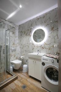 a bathroom with a toilet sink and a washing machine at #7 Ioanna Apartments in Thessaloniki