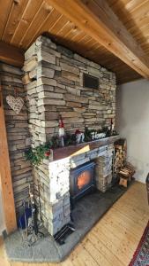 a fireplace in a room with a stone wall at Rogla - Chalet Mojca Pokrajculja in Zreče