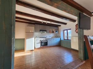 a kitchen with white appliances and a tile floor at Maison de Vacances in Le Thillot