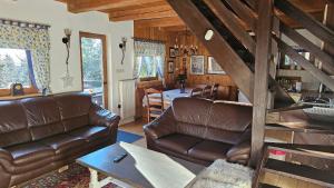 a living room with leather couches and a dining room at Rogla - Chalet Mojca Pokrajculja in Zreče