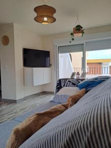 sypialnia z dwoma łóżkami i telewizorem z płaskim ekranem w obiekcie Apartamento CANELA w mieście Isla Canela