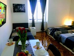 a room with two beds and a table with fruit on it at Pula-Center Apartments and Rooms in Pula