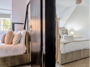 Darla Cottage في ثورنتون دالي: غرفة نوم بسريرين ومرآة فيها